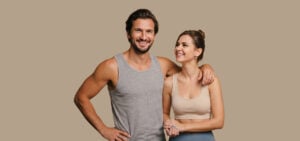 A smiling man and woman in athletic wear, representing the energy and vitality peptide therapy patients pursue.